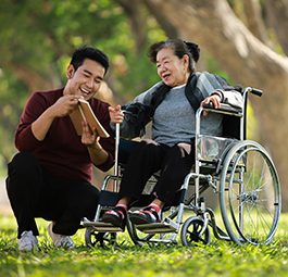 Man helping senior woman in wheelchair