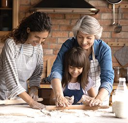 Girl, mother, and grandmother baking