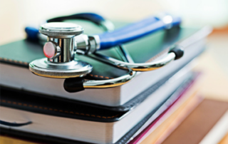 A stethoscope sitting on top of multiple journals.