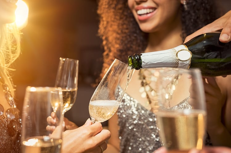 woman with a glass of champagne being poured.