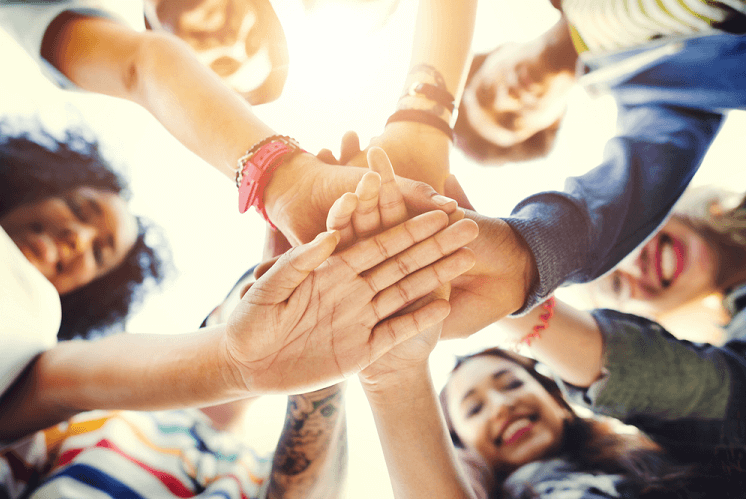 A group of friends reach in to show solidarity