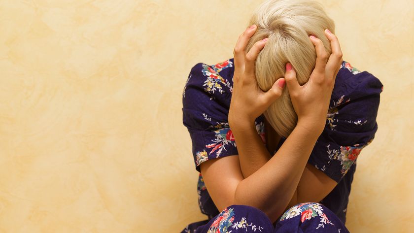 Woman clutching her head in anguish.