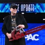 Elon Musk holds a chainsaw reading "Long live freedom, damn it" during the annual Conservative Political Action Conference (CPAC) at the Gaylord National Resort & Convention Center at National Harbor in Oxon Hill, Maryland, on February 20, 2025.