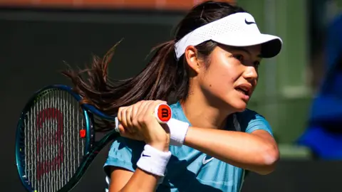 Emma Raducanu hits a return during practice in Indian Wells