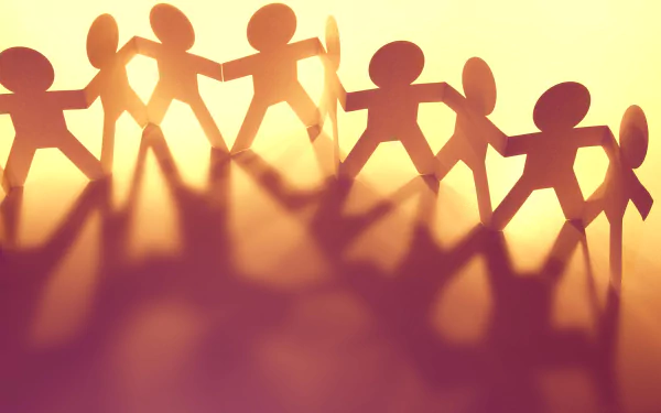 HD wallpaper featuring silhouette of paper chain of friends holding hands with a motivational vibe on a warm, glowing background.