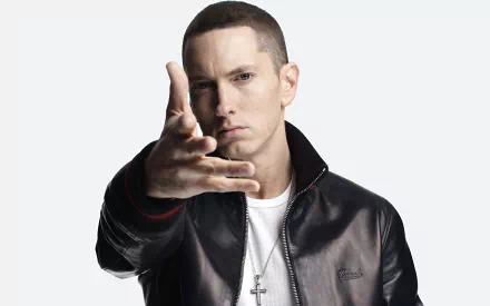 A striking HD wallpaper featuring Eminem, a prominent figure in rap music, confidently posing with an outstretched hand, embodying his powerful presence in the genre.