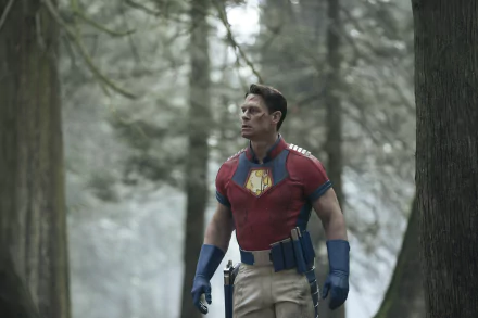 Peacemaker (DC Comics) in a red shirt and utility belt standing in a misty forest — TV show 2K Quad HD PC desktop wallpaper/background.