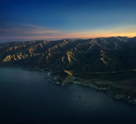 Apple Inc. 5K Ultra HD PC desktop wallpaper, aerial view of Big Sur coastline, rugged mountains meeting the ocean at sunset — a dramatic nature landscape.