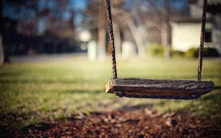 HD photography of an empty wooden swing hanging outdoors with a blurred background, captured as a desktop wallpaper and background image.