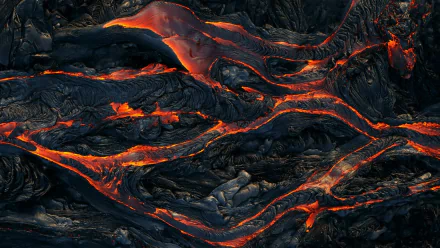 HD PC desktop wallpaper showcasing glowing lava flowing across rugged volcanic terrain, highlighting the raw power of nature.