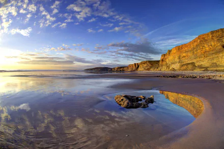 4K Ultra HD desktop wallpaper showing the Wales coastline with cliffs, ocean, beach, and a vivid horizon under a partly cloudy sky.