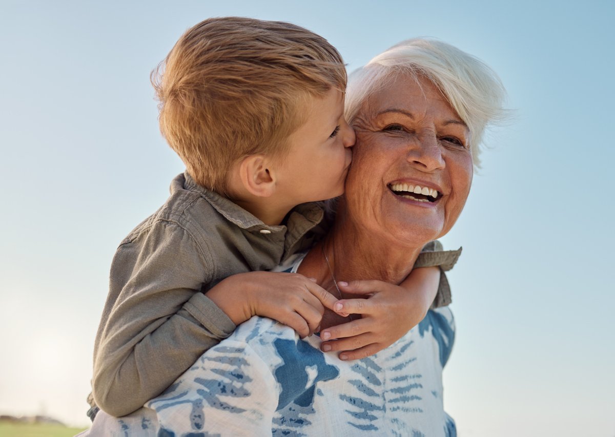 Grandmother and grandson on the beach smiling