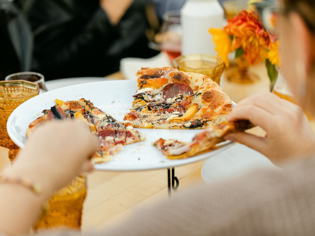 Guests eating pizza at rehearsal dinner