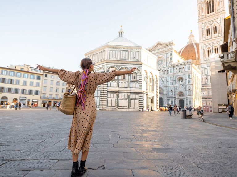  Women enjoys the view of a plaza in Florence with the famous Duomo cathedral in the background. 