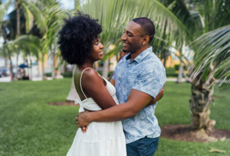 Couple huggin in front of palm trees, Miami engagement photo locations