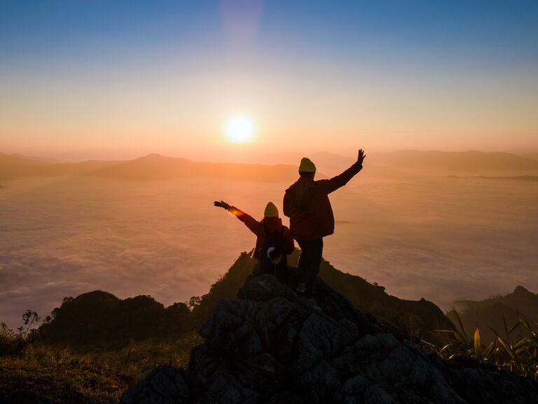 Couple posing on peak of mountain