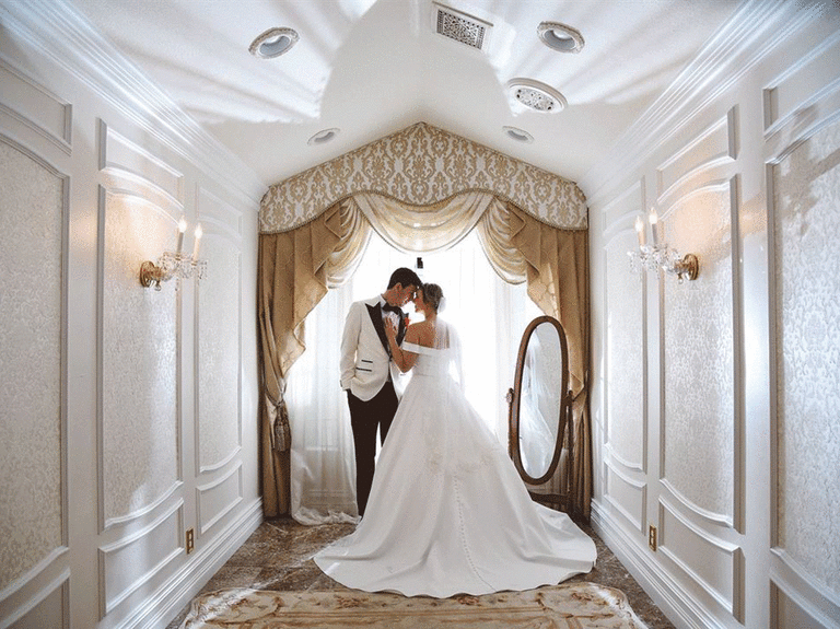 Couple poses in the hallway of Chapel of Flowers. 