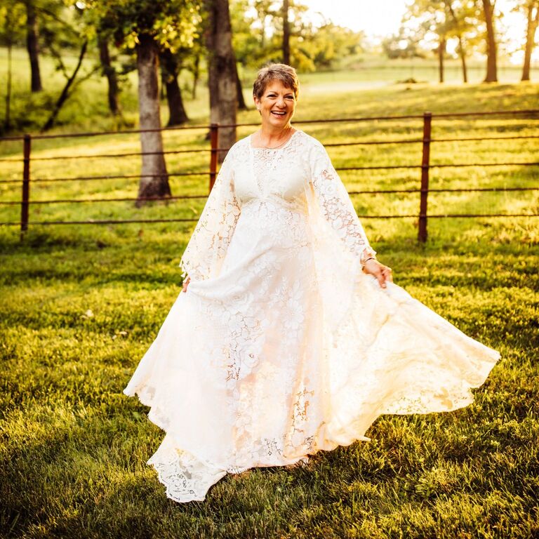 Smiling bride wears a timeless and sleek pixie hairstyle. 