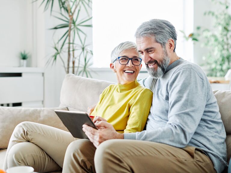 Couple adding gift cards to their wedding registry on laptop at home