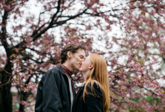 March Captions - A couple kissing under cherry blossom trees