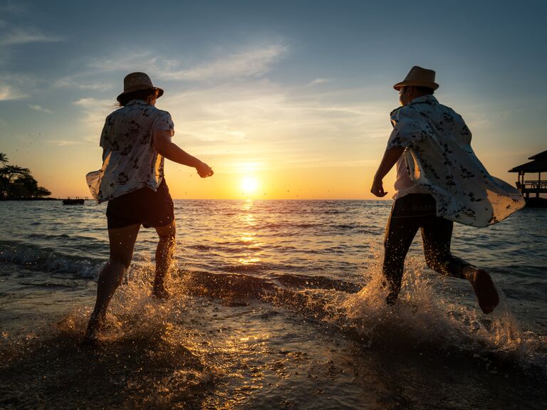 Couple running into ocean