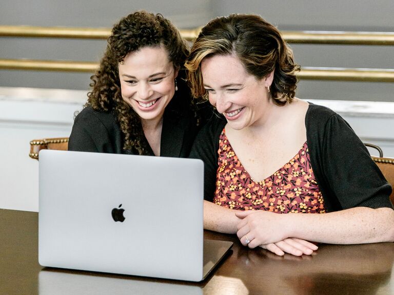 Engaged couple starting their wedding registry on laptop at home