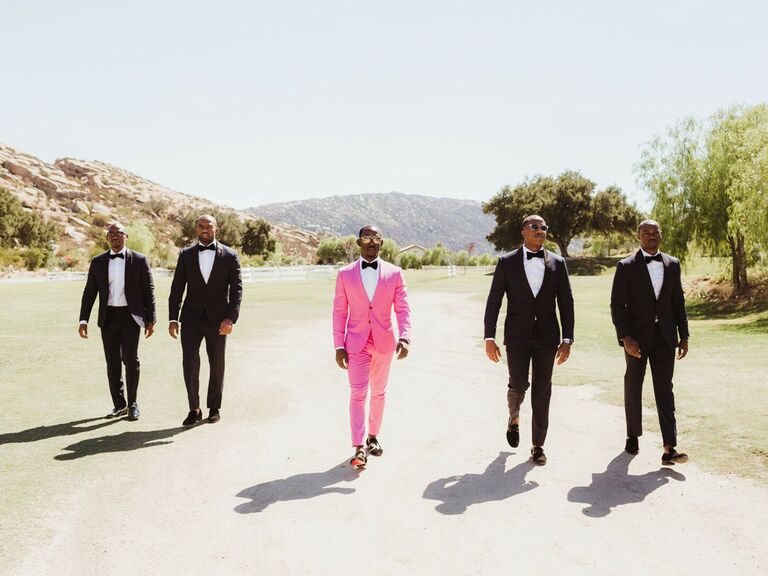 Groomsmen and groom walking into wedding reception