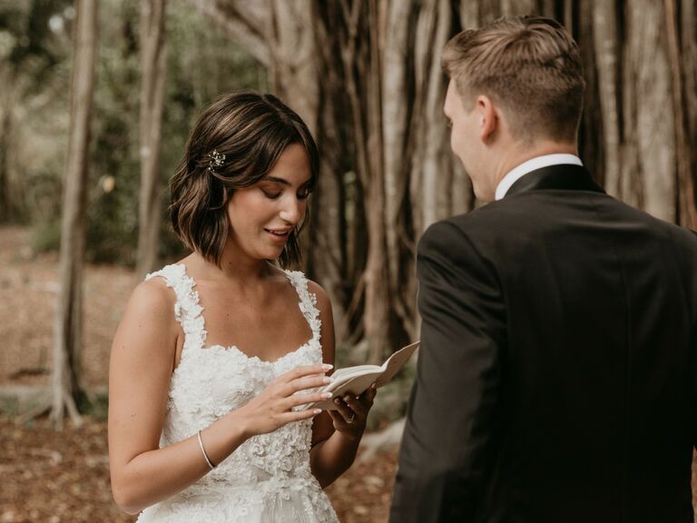 Bride reads her vows in a beautiful woodsy ceremony while her partner looks on. 