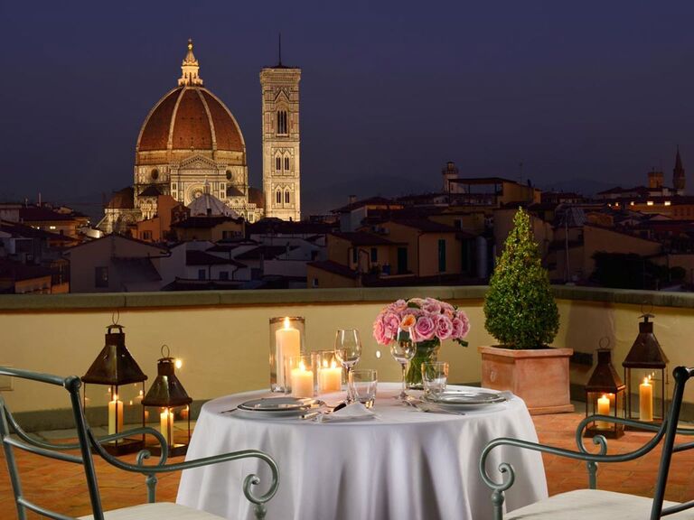 View of a dining table on an outdoor terrace overlooking the Duomo. 