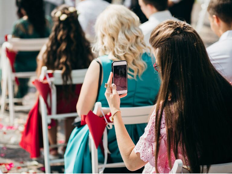 Wedding guest taking photo at wedding ceremony