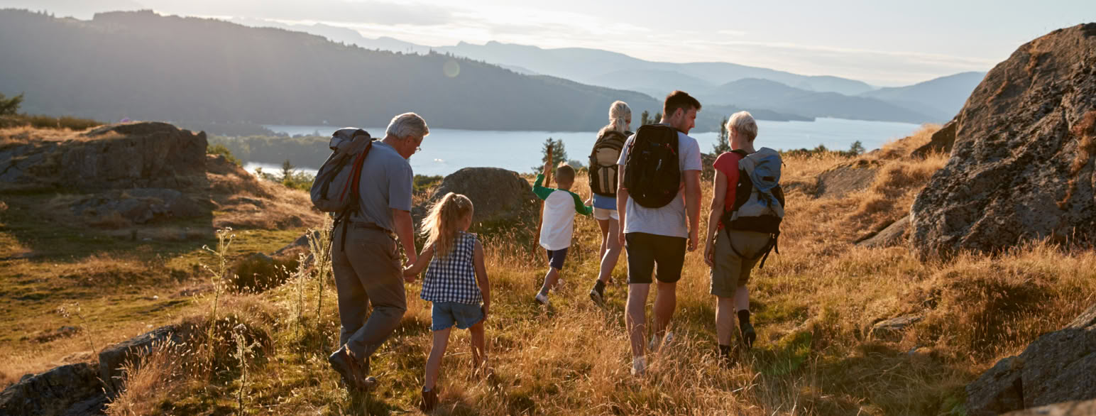 Familie med folk i mange aldre går tur på fjell