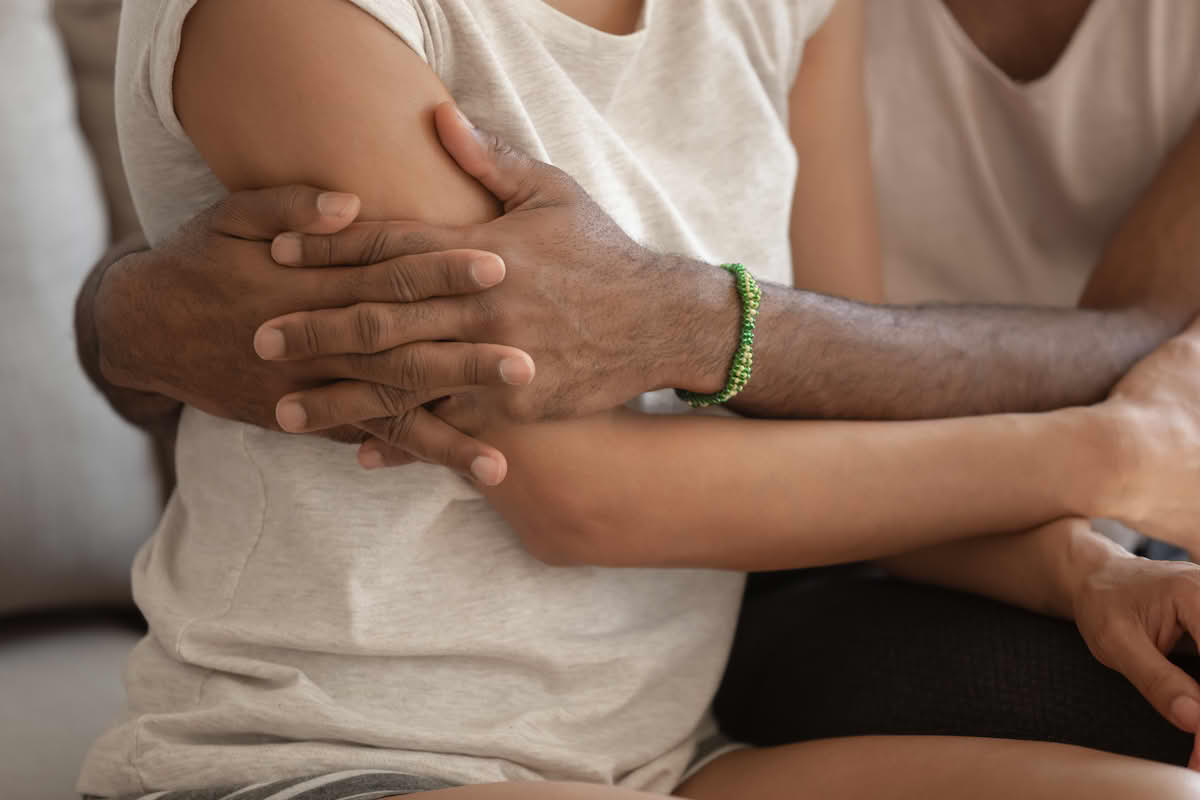 Foto av en melaninrik mann og en kvinne som holder rundt hverandre.