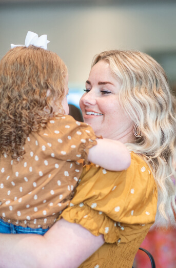 Mother holding her child at an MPS awareness event