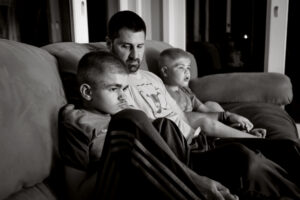 Ryan Kapes, 11, left, with his dad Carl and brother Brayden, 8, watch The Backyardigans at their home in Wilmington, Delaware. 