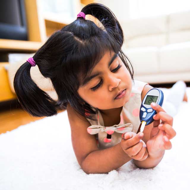 Little girl testing her blood sugar levels.