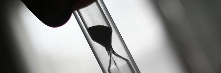 close up of sand passing through an hourglass