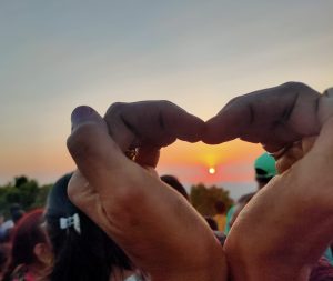 Capturing Love: Sunset Framed in Heart-Shaped Hands