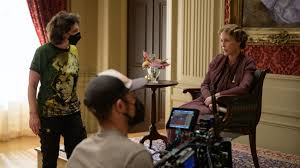 Camera crew with masks on filming an actor