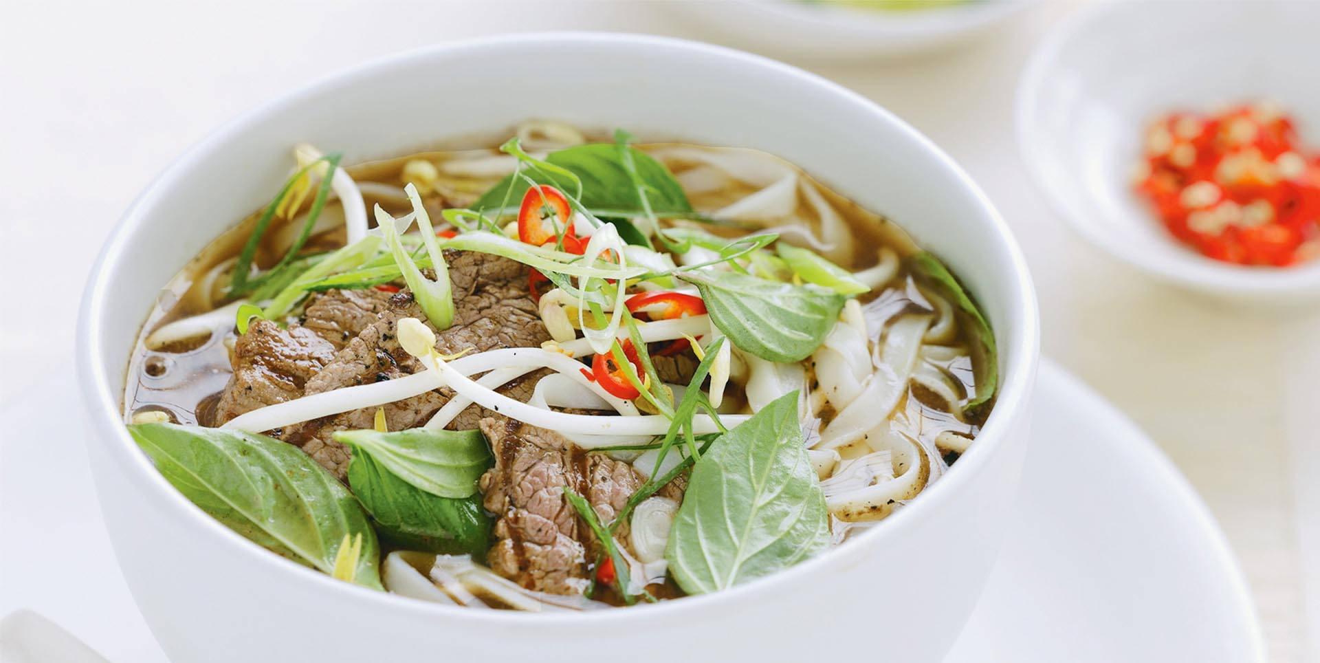 Bijschrift: Een Verleidelijke Kom Traditionele Vietnamese Pho. Achtergrond