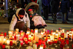 スイス南西部クランモンタナで2026年1月2日、火災が起きたバーの近くで追悼のろうそくを置く男性＝ロイター