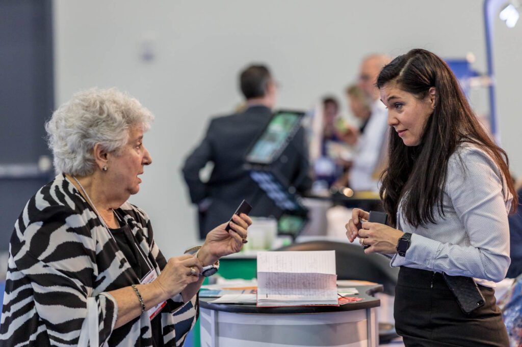 Exhibitor and meeting attendee discussing genetics and genomics 