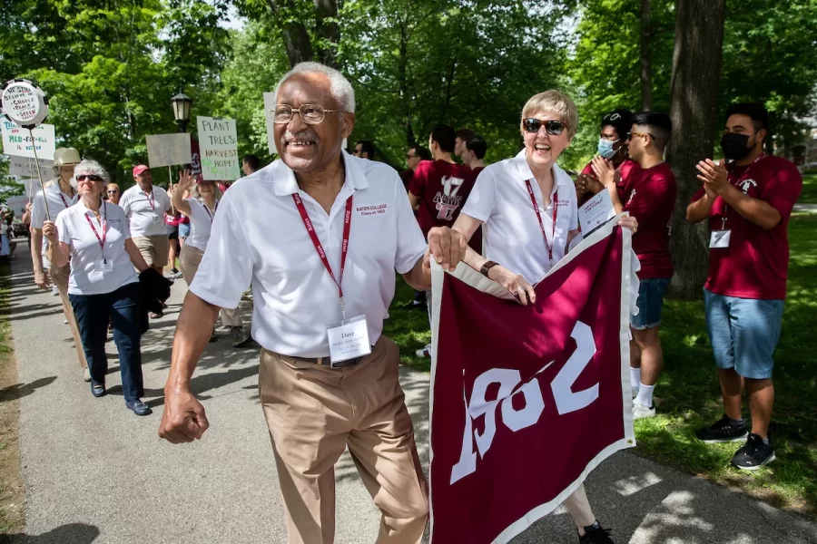 Photo of an older man holding a 1982 class banner in a parade