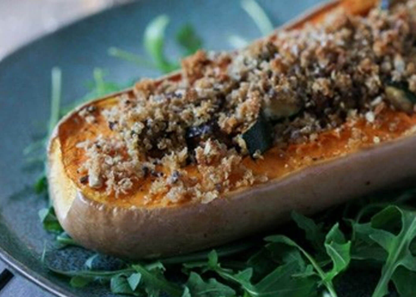 Vegan stuffed butternut squash with roast vegetables and breadcrumbs