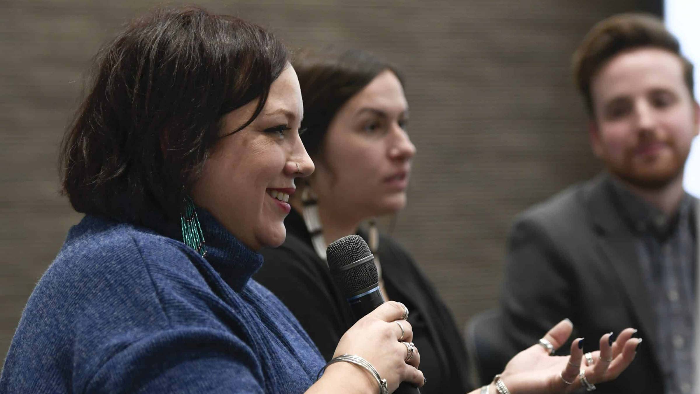 A panel speaker holds a microphone and addresses the crowd