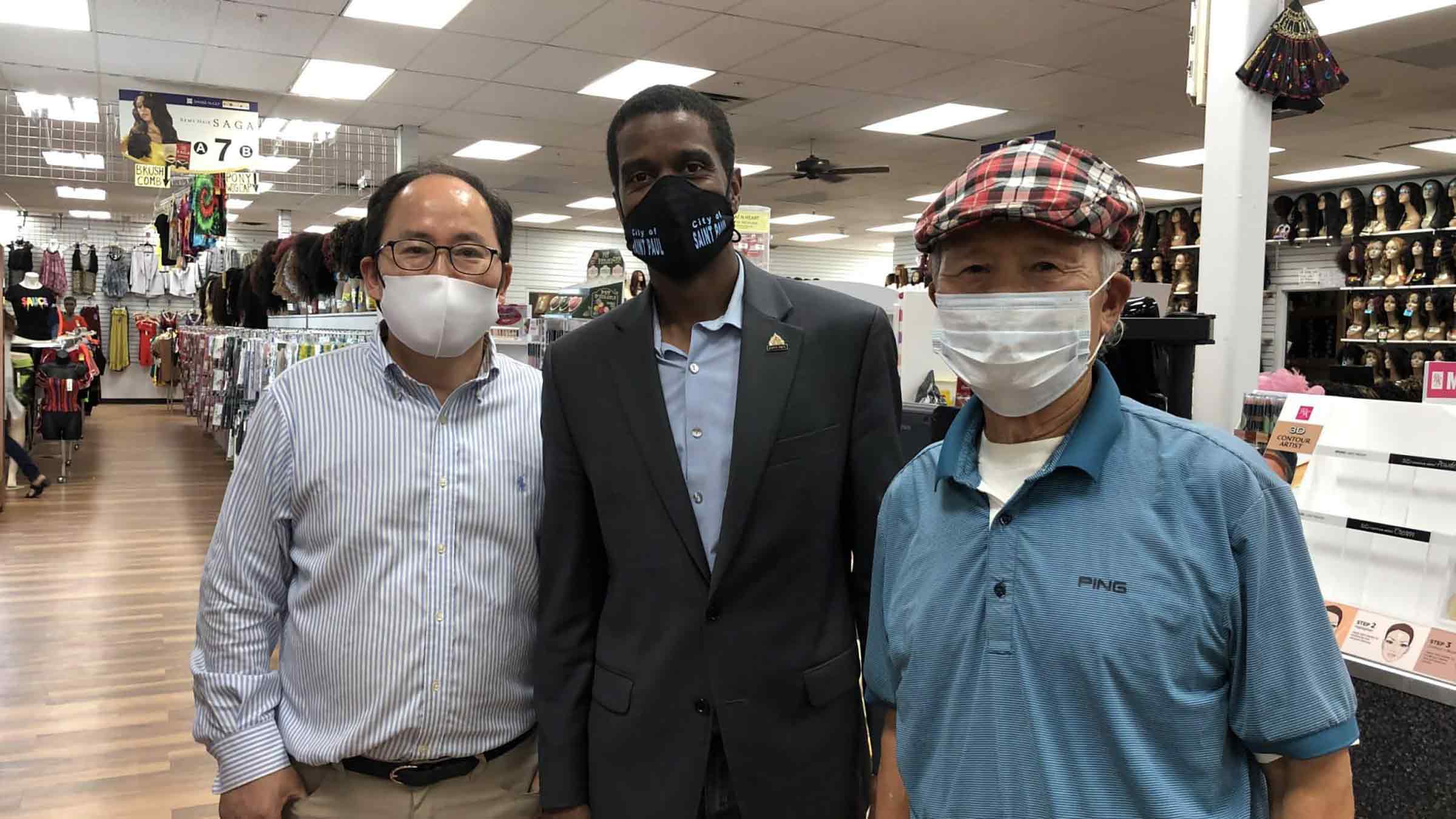 Three men stand together in a shop