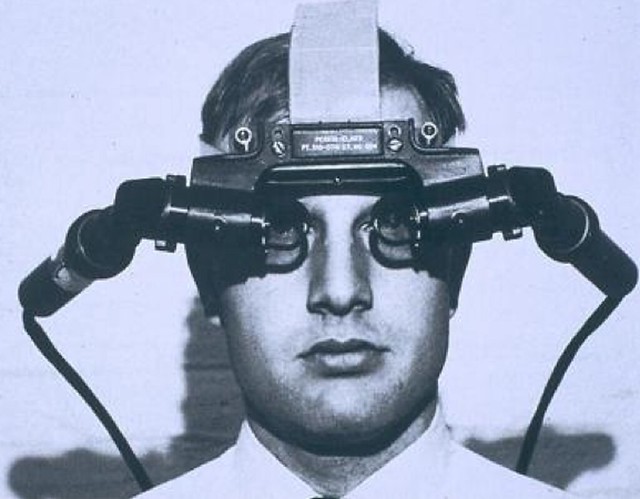 A person wearing an early virtual reality helmet