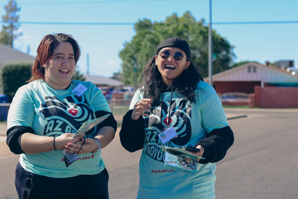 Two people in AZ AANHPI Advocates shirt smiling at camera.