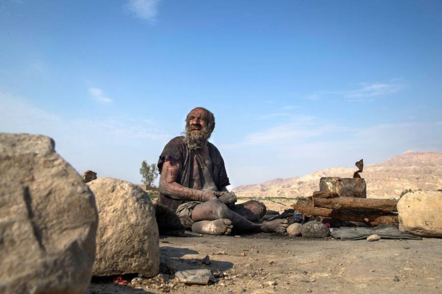 Amou Haji Sitting On The Ground