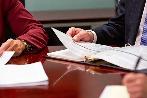 Business formation photo of hands looking through legal binder