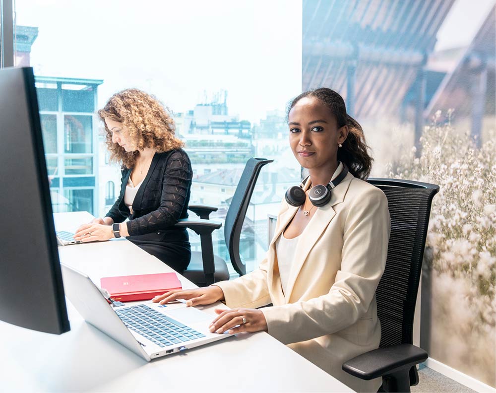 Two female office workers working at their desks in an office